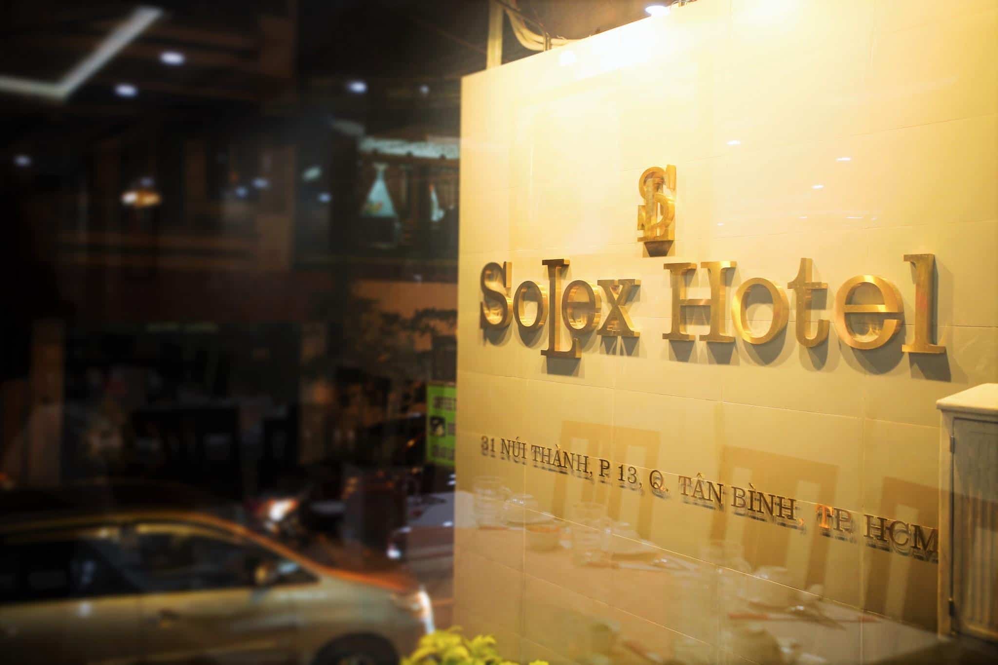 Khách sạn nhìn từ ngoài vào với dòng chữ Solex Hotel in màu vàng nổi bật
